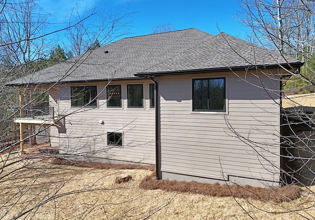 back of property with a shingled roof