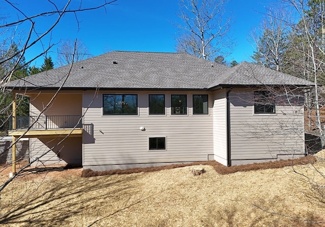 rear view of property featuring stairway and roof with shingles