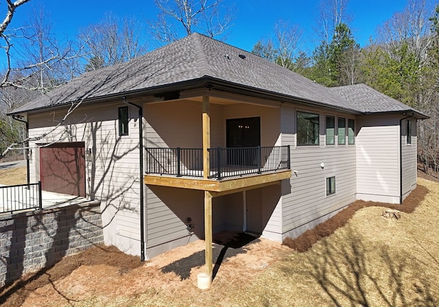 rear view of property with a shingled roof