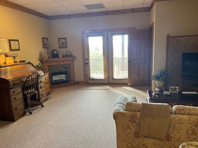 office space featuring a paneled ceiling, light colored carpet, and a fireplace