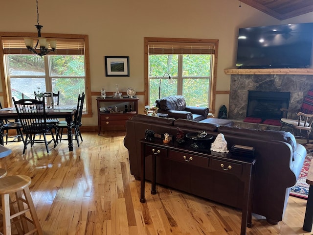 living room with crown molding, light hardwood / wood-style flooring, a chandelier, and a high end fireplace