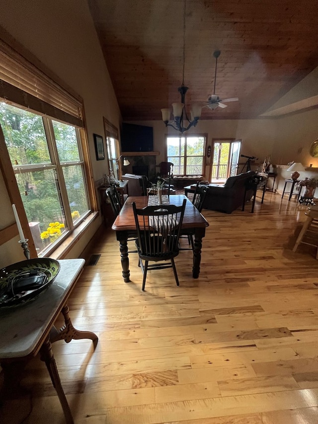 dining area with lofted ceiling, light hardwood / wood-style flooring, and plenty of natural light