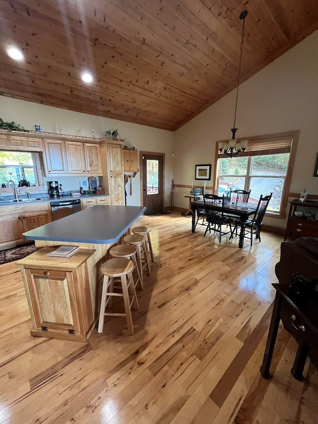 kitchen with plenty of natural light, a center island, hanging light fixtures, and light wood-type flooring