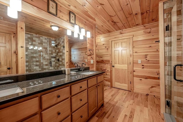 bathroom with a stall shower, wooden ceiling, a sink, and wood finished floors