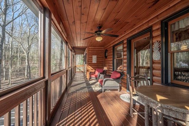 unfurnished sunroom featuring wooden ceiling and a ceiling fan