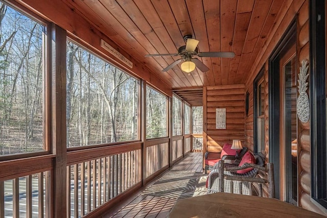 unfurnished sunroom with a ceiling fan and wood ceiling