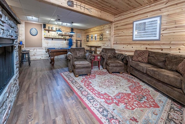 living room featuring billiards, wooden walls, and wood finished floors