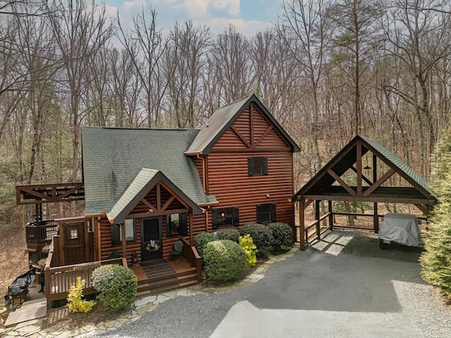 cabin with roof with shingles and log veneer siding