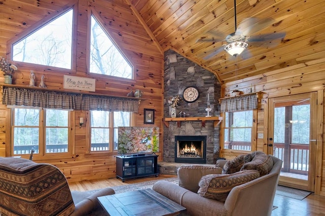 living room with a fireplace, light wood-style flooring, wooden walls, high vaulted ceiling, and wooden ceiling