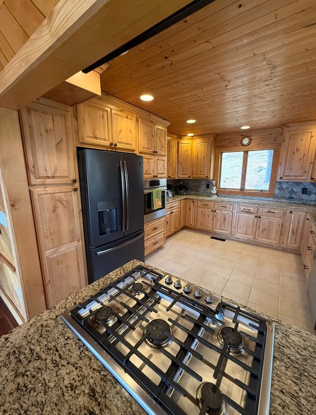 369 Deals Gap Rd, Robbinsville, NC 28771 - kitchen with appliances with stainless steel finishes, light tile patterned floors, light stone countertops, decorative backsplash, and wooden ceiling