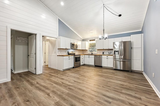 kitchen with stainless steel appliances, white cabinets, and light wood-type flooring