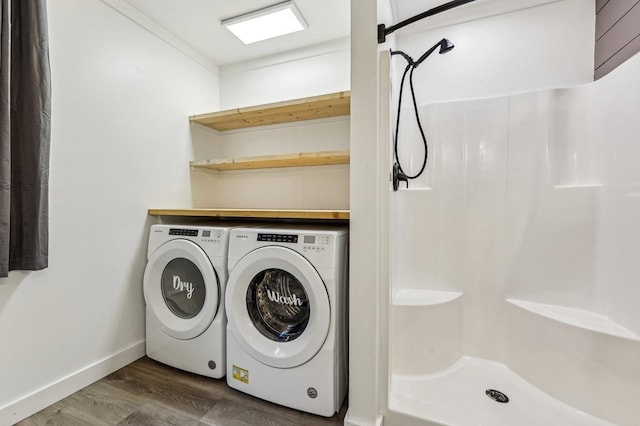 clothes washing area with dark wood-type flooring and independent washer and dryer