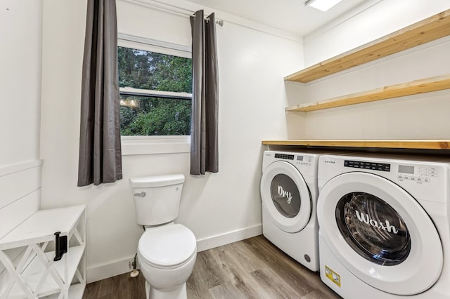 laundry room with washing machine and clothes dryer and hardwood / wood-style flooring