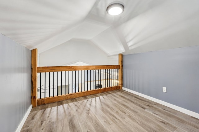 bonus room with vaulted ceiling and light hardwood / wood-style flooring