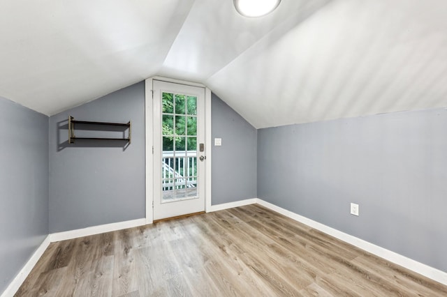 additional living space featuring light wood-type flooring and lofted ceiling