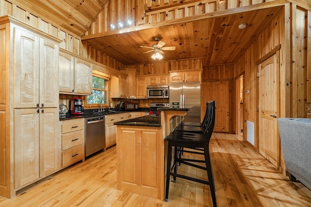 kitchen featuring a kitchen island, wooden ceiling, appliances with stainless steel finishes, lofted ceiling, and ceiling fan