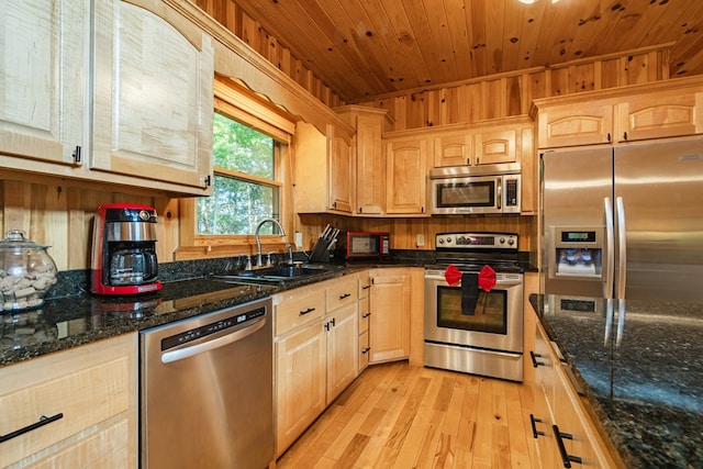 kitchen featuring appliances with stainless steel finishes, wood ceiling, sink, dark stone countertops, and light wood-type flooring