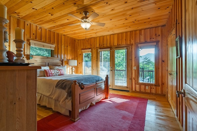 bedroom with wood ceiling, hardwood / wood-style floors, wooden walls, and access to outside