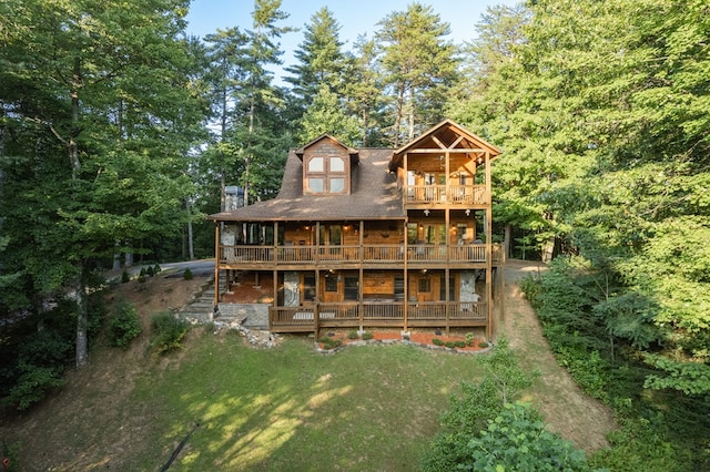 rear view of property featuring a yard and a balcony