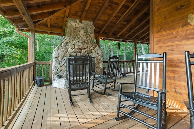 deck with an outdoor stone fireplace