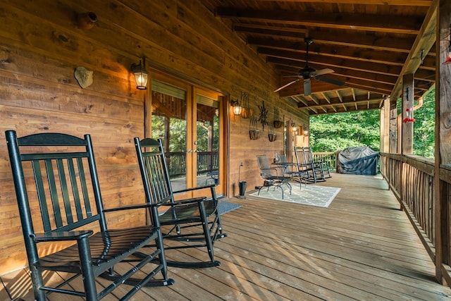 wooden deck featuring ceiling fan, grilling area, and a porch