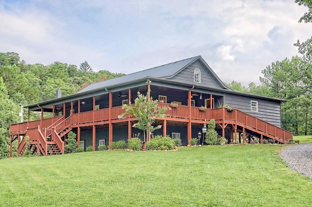 rear view of property featuring a lawn and ceiling fan