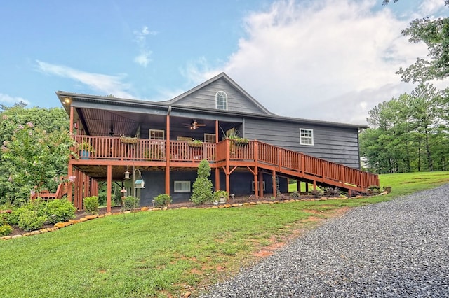 view of front of house with a wooden deck, ceiling fan, and a front lawn