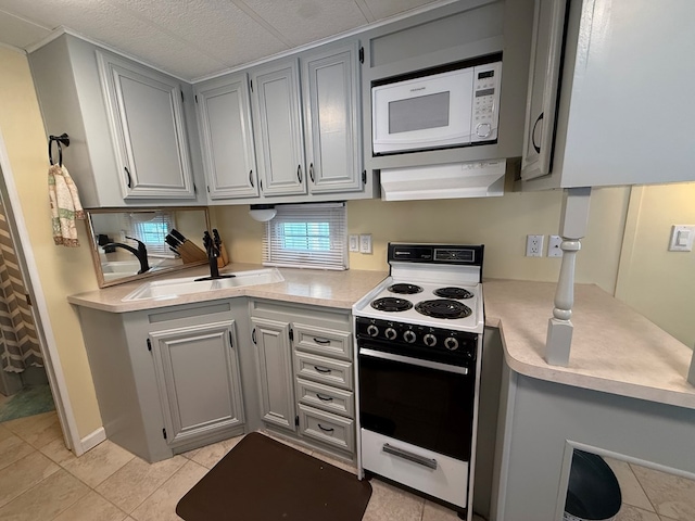 kitchen featuring a sink, gray cabinets, white appliances, and light countertops