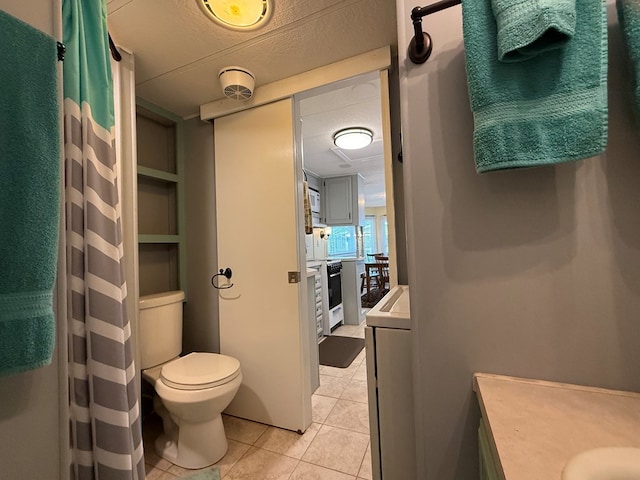 full bath featuring vanity, toilet, tile patterned floors, washer / dryer, and curtained shower