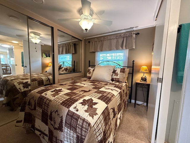bedroom featuring carpet floors, a ceiling fan, and multiple closets