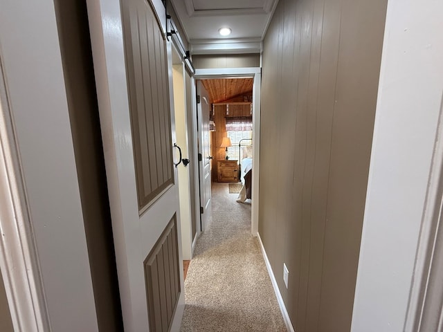 hall with light carpet and wood walls