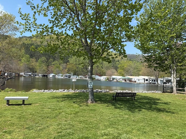 surrounding community featuring a yard, a water view, and a wooded view
