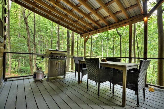 deck with area for grilling and a wooded view