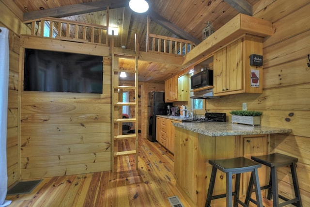 kitchen with wooden walls, visible vents, light brown cabinetry, black appliances, and wood ceiling
