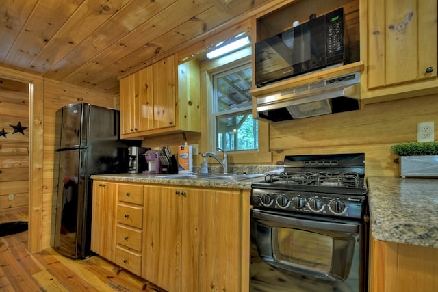 kitchen with light wood-style flooring, a sink, black appliances, wood ceiling, and under cabinet range hood