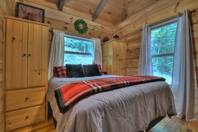 bedroom with lofted ceiling with beams, hardwood / wood-style flooring, multiple windows, and wooden ceiling