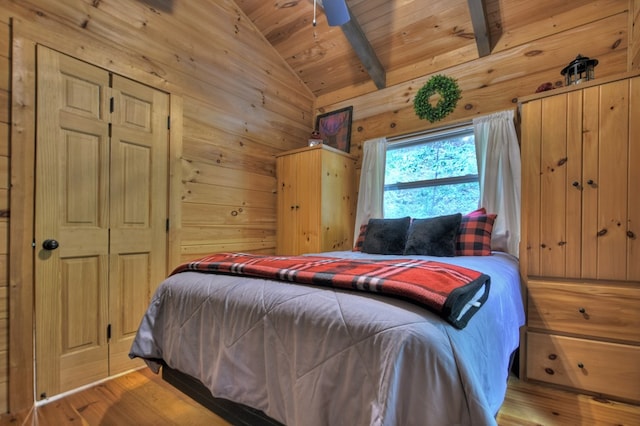 bedroom with wood finished floors, wood ceiling, wood walls, and vaulted ceiling with beams