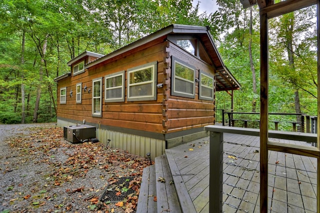 view of property exterior with a wooden deck and central AC