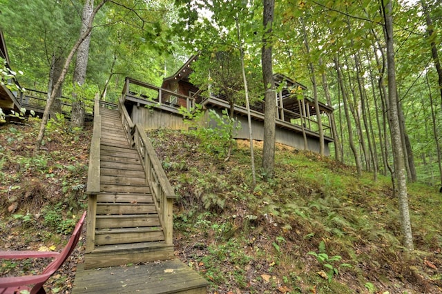 view of yard featuring a forest view and stairs