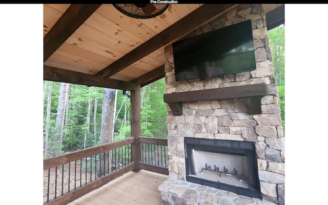 wooden terrace featuring an outdoor stone fireplace