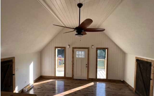 additional living space with lofted ceiling, dark hardwood / wood-style floors, and ceiling fan