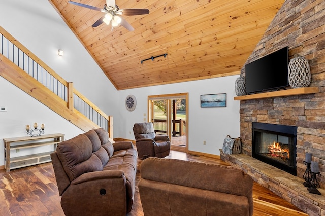 living room featuring wood ceiling, ceiling fan, high vaulted ceiling, dark wood-type flooring, and a stone fireplace