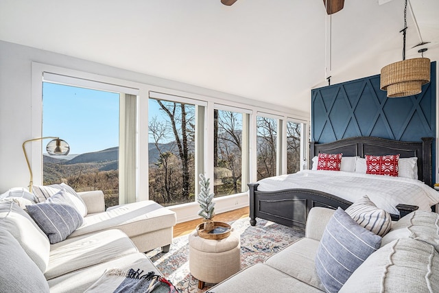 bedroom with hardwood / wood-style flooring, a mountain view, and ceiling fan