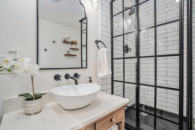 bathroom featuring a tile shower and vanity