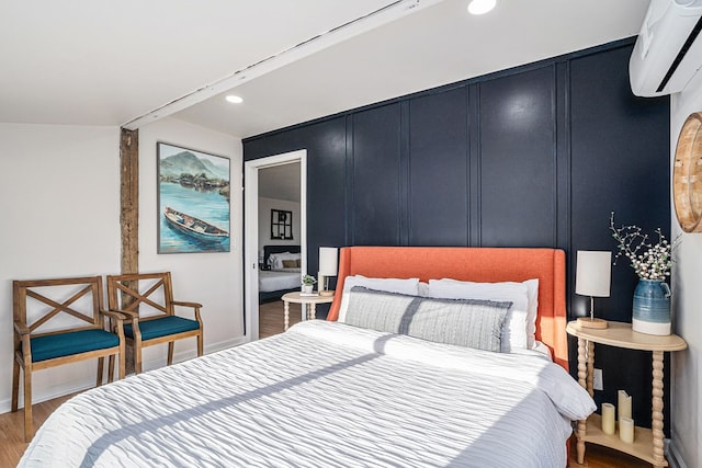 bedroom with wood-type flooring and a wall mounted AC