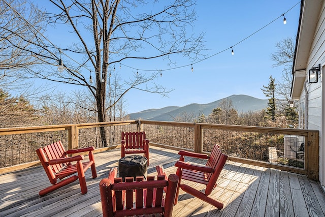 wooden terrace with a mountain view and a fire pit