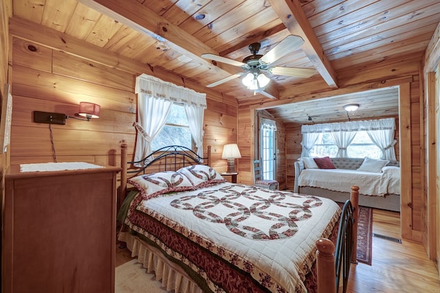 bedroom with wooden ceiling, wood walls, multiple windows, beam ceiling, and light wood-type flooring