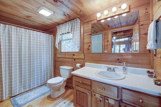 full bath featuring toilet, wooden walls, vanity, and wood finished floors