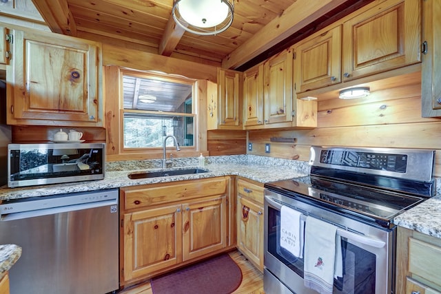 kitchen with beamed ceiling, a sink, stainless steel appliances, wooden ceiling, and light stone countertops