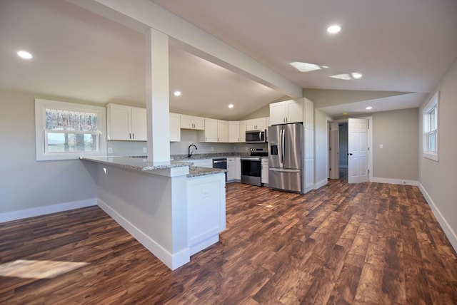 kitchen featuring vaulted ceiling with beams, stainless steel appliances, white cabinetry, light stone countertops, and a peninsula